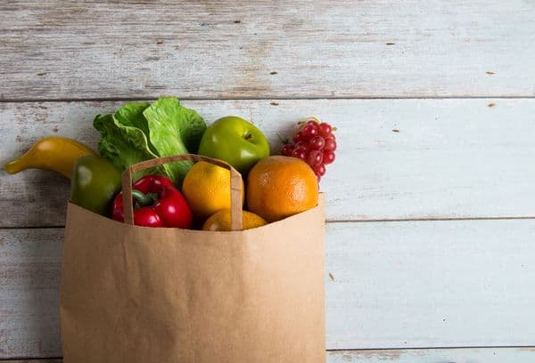 Papīra maisiņš ar dārzeņiem un augļiem.