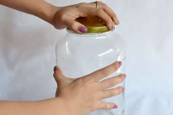 Woman closes the jar with a lid