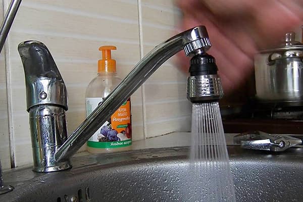 Разпръскване на водна дюза по крана в кухнята