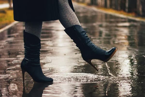 Girl walks in boots through the puddles