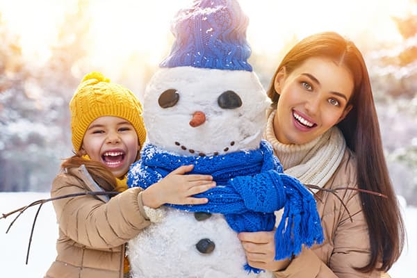 Mama și fiica sculptă un om de zăpadă